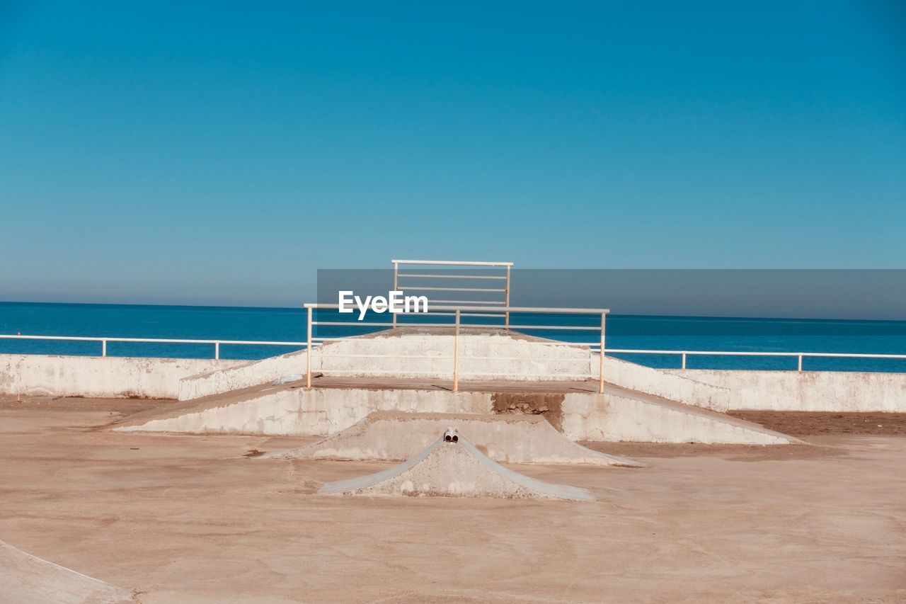Scenic view of beach against clear blue sky