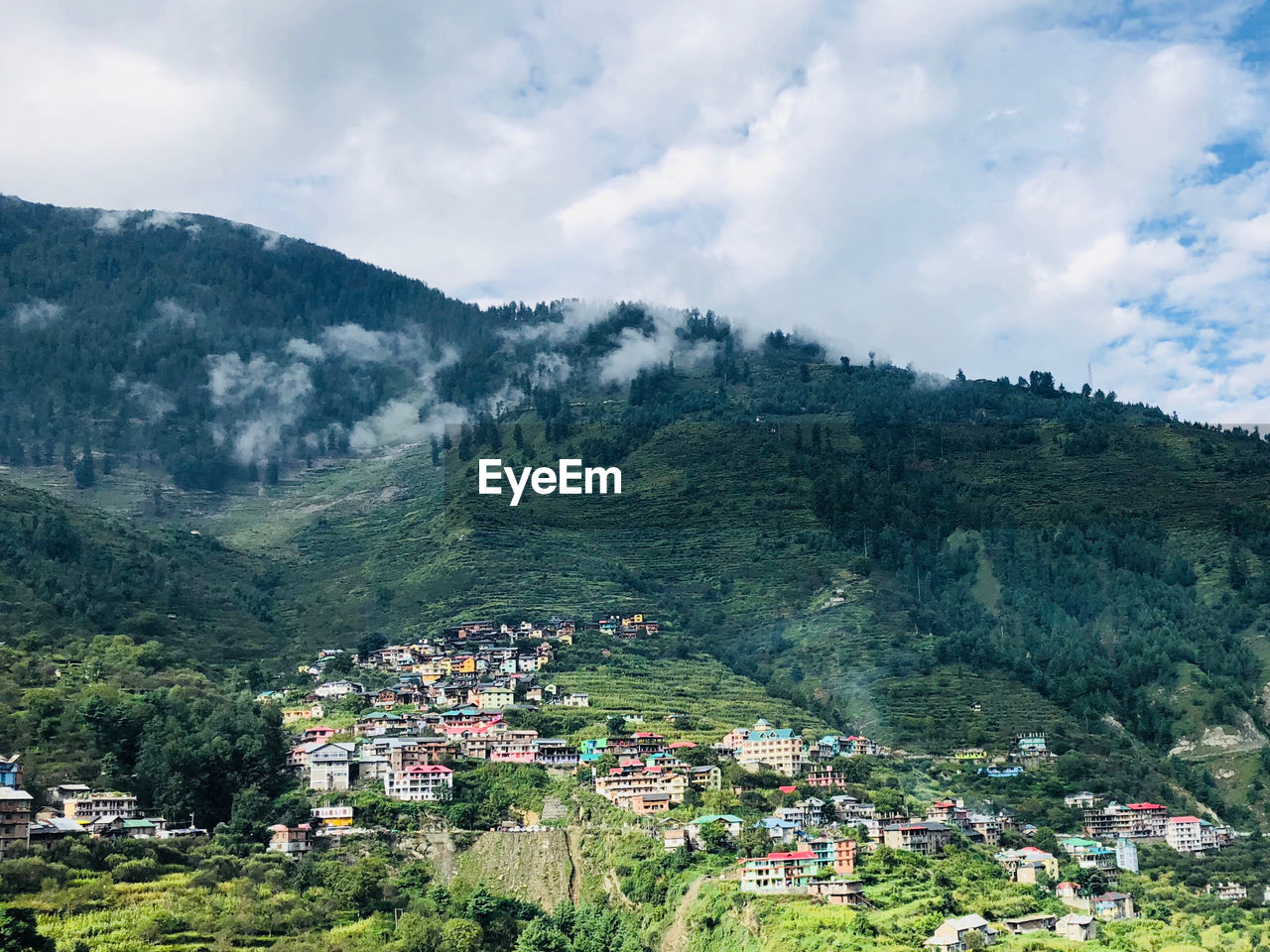 Aerial view of townscape by mountain against sky