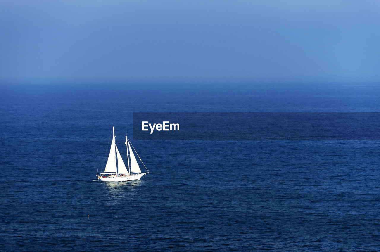 Sailboat sailing on sea against sky