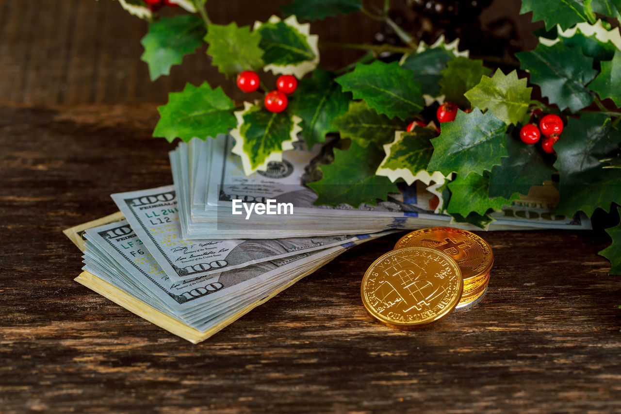 High angle view of money with leaves on wooden table