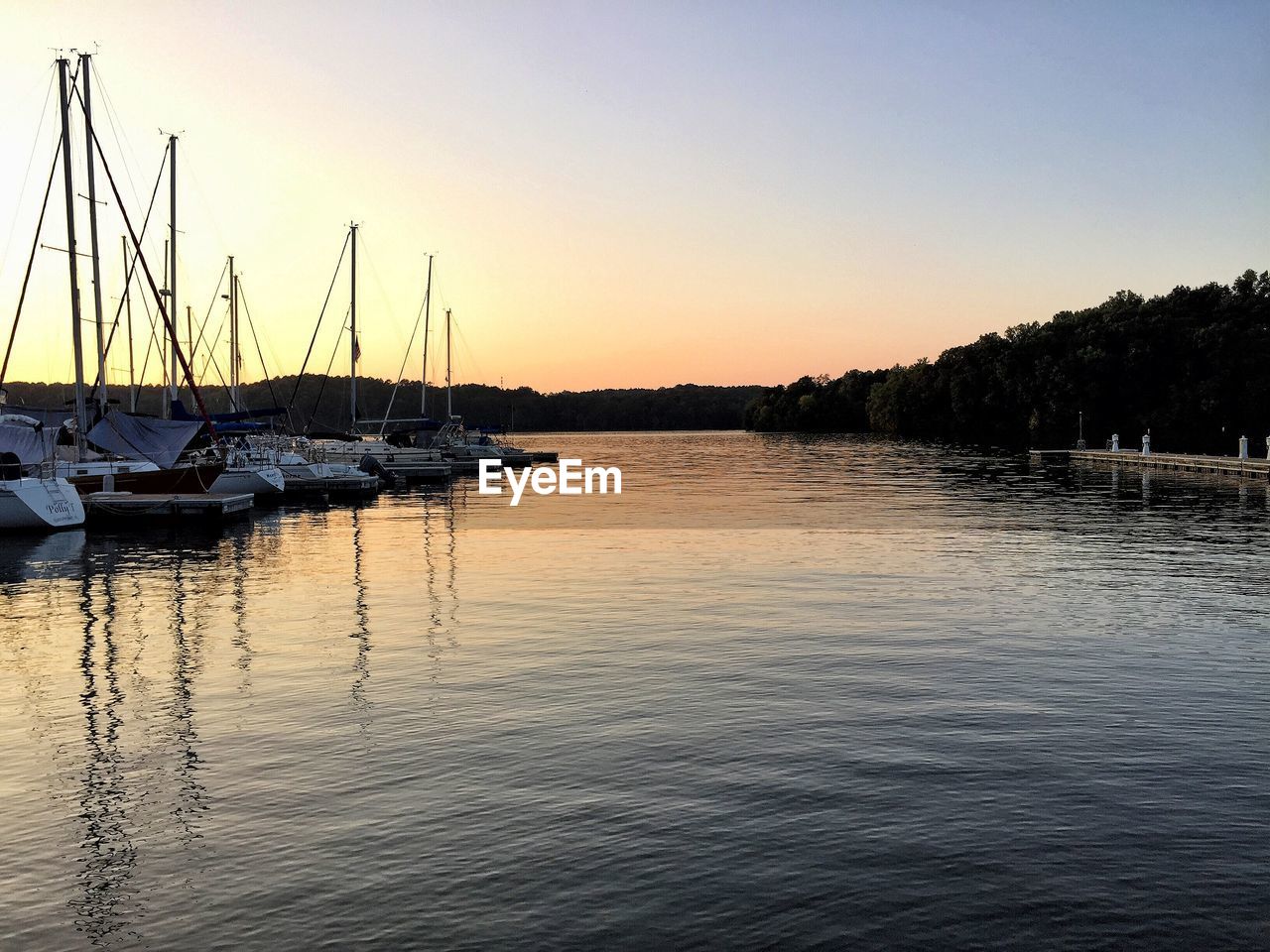 SAILBOATS IN SEA AT SUNSET