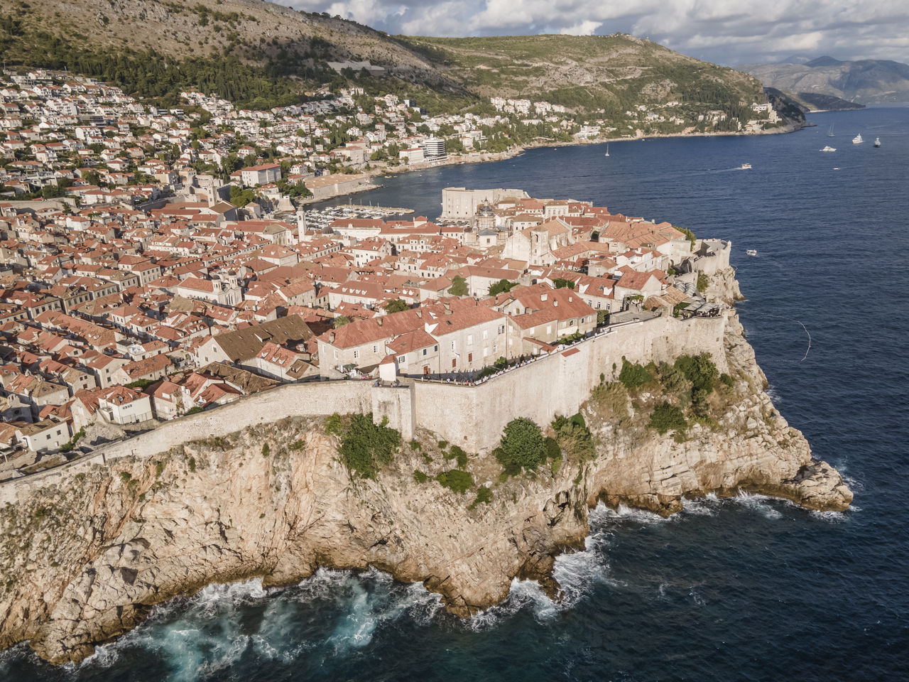 HIGH ANGLE VIEW OF TOWNSCAPE BY SEA AGAINST MOUNTAINS