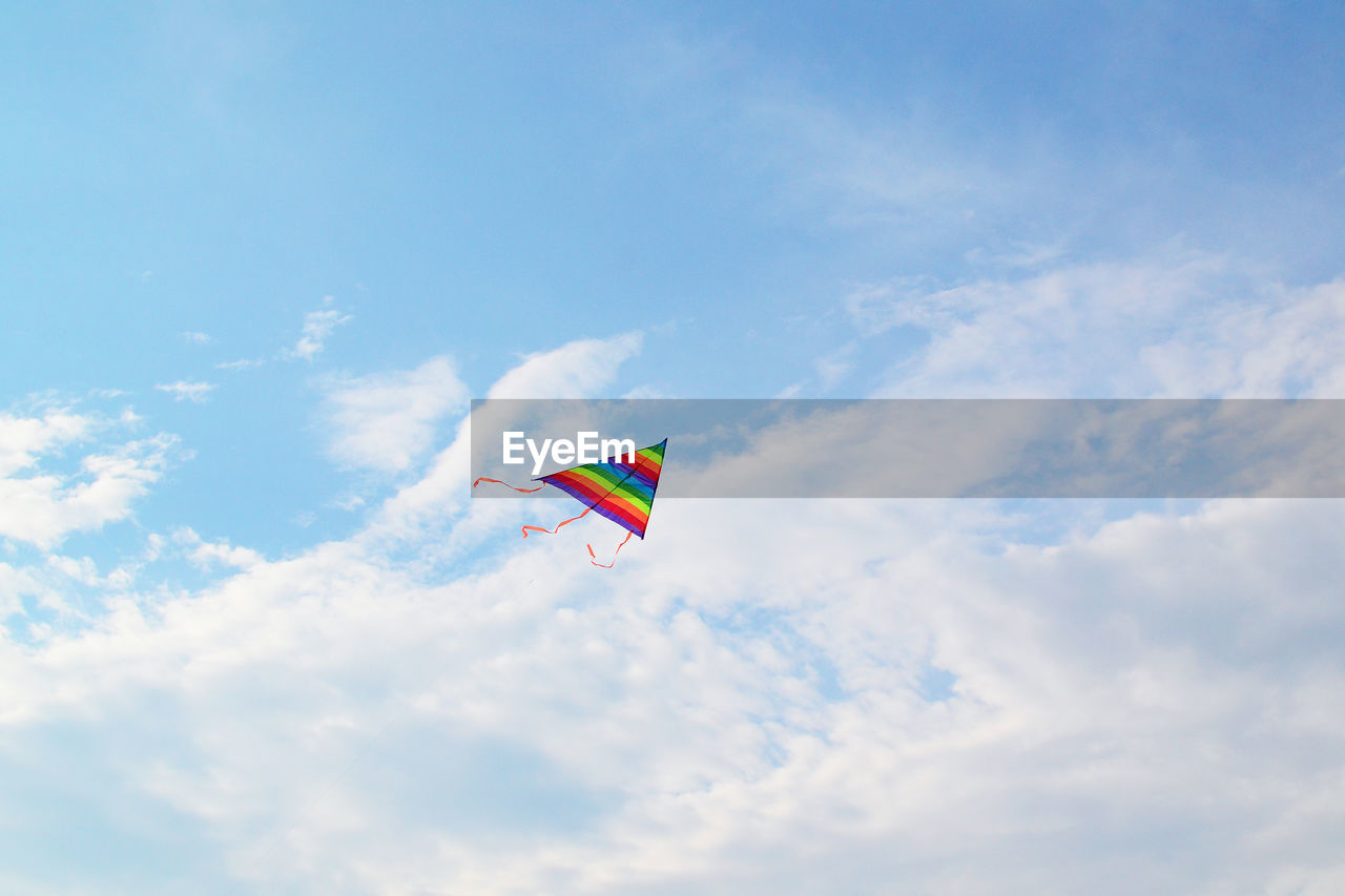 LOW ANGLE VIEW OF KITE FLYING AGAINST BLUE SKY
