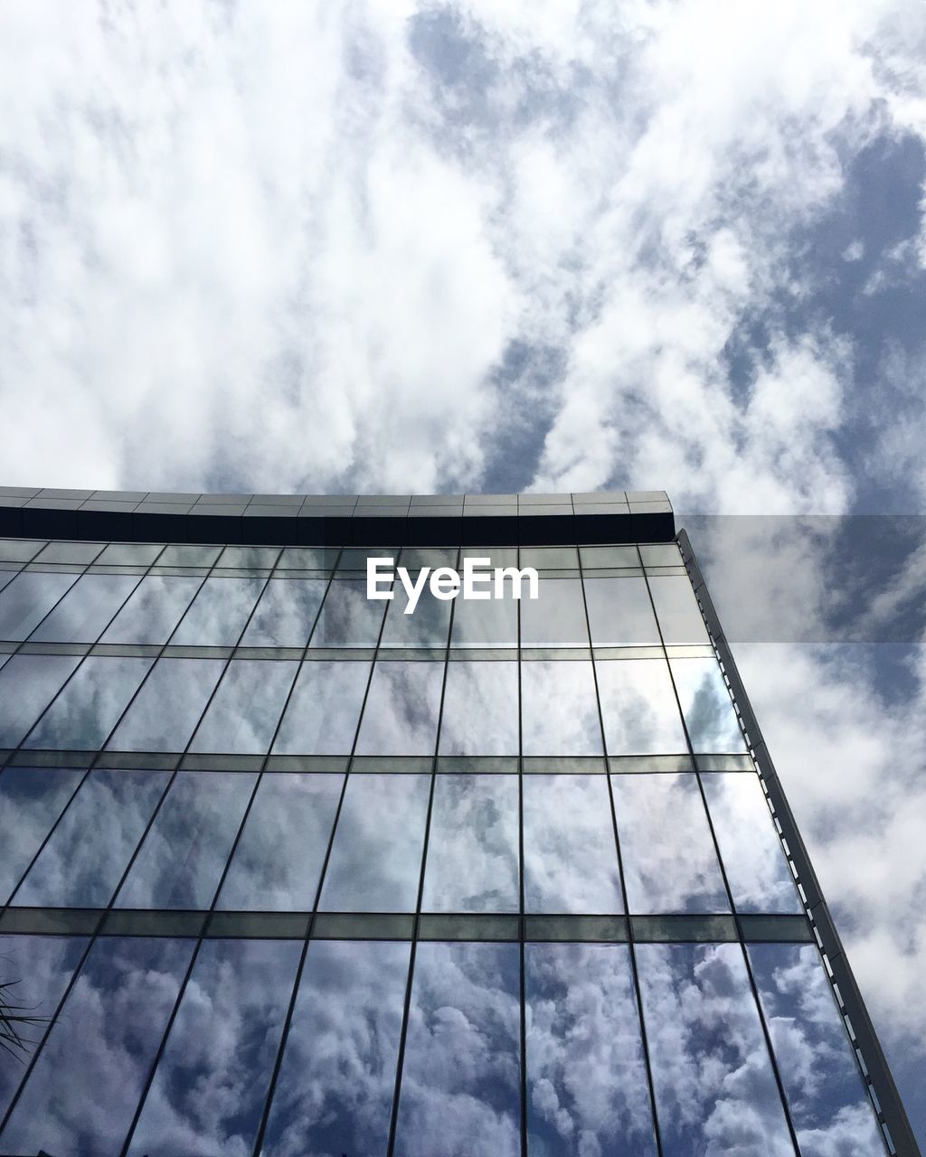 Low angle view of modern building against cloudy sky