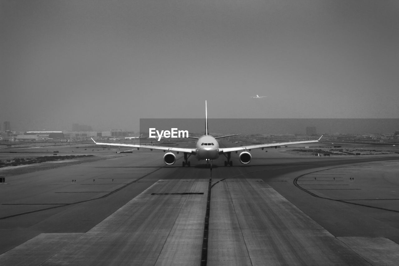 Airplane on runway against sky