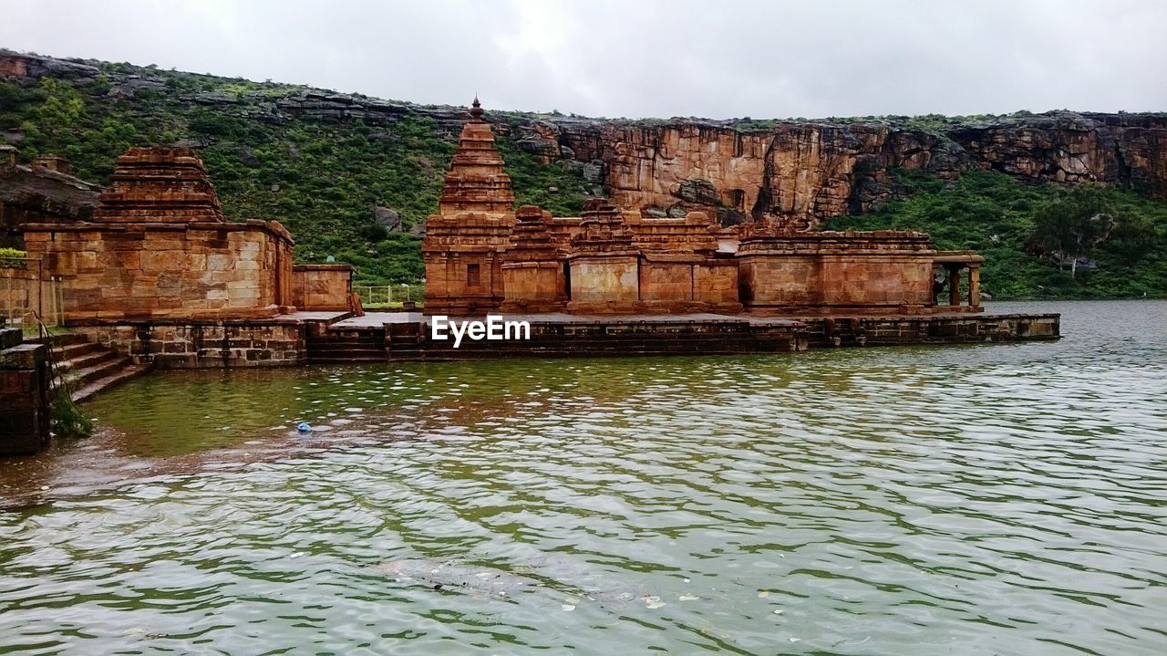 BUILT STRUCTURE BY WATER AGAINST SKY