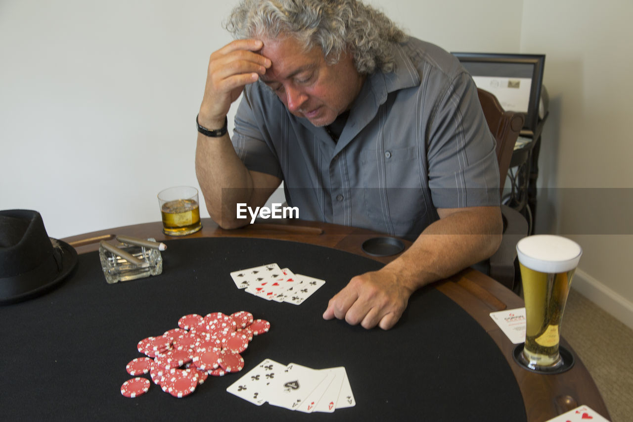 Man playing poker while sitting at table