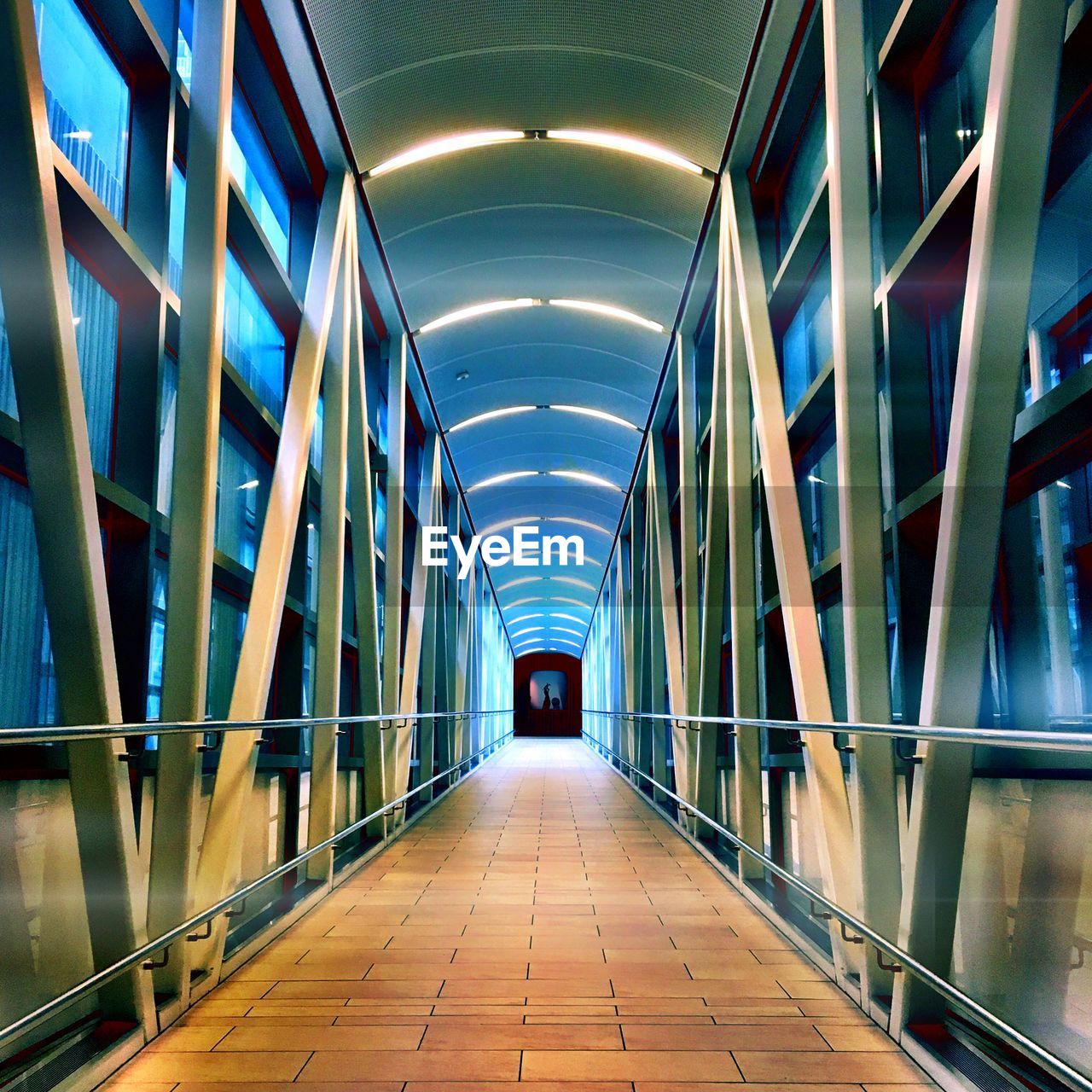 Illuminated empty elevated walkway at night