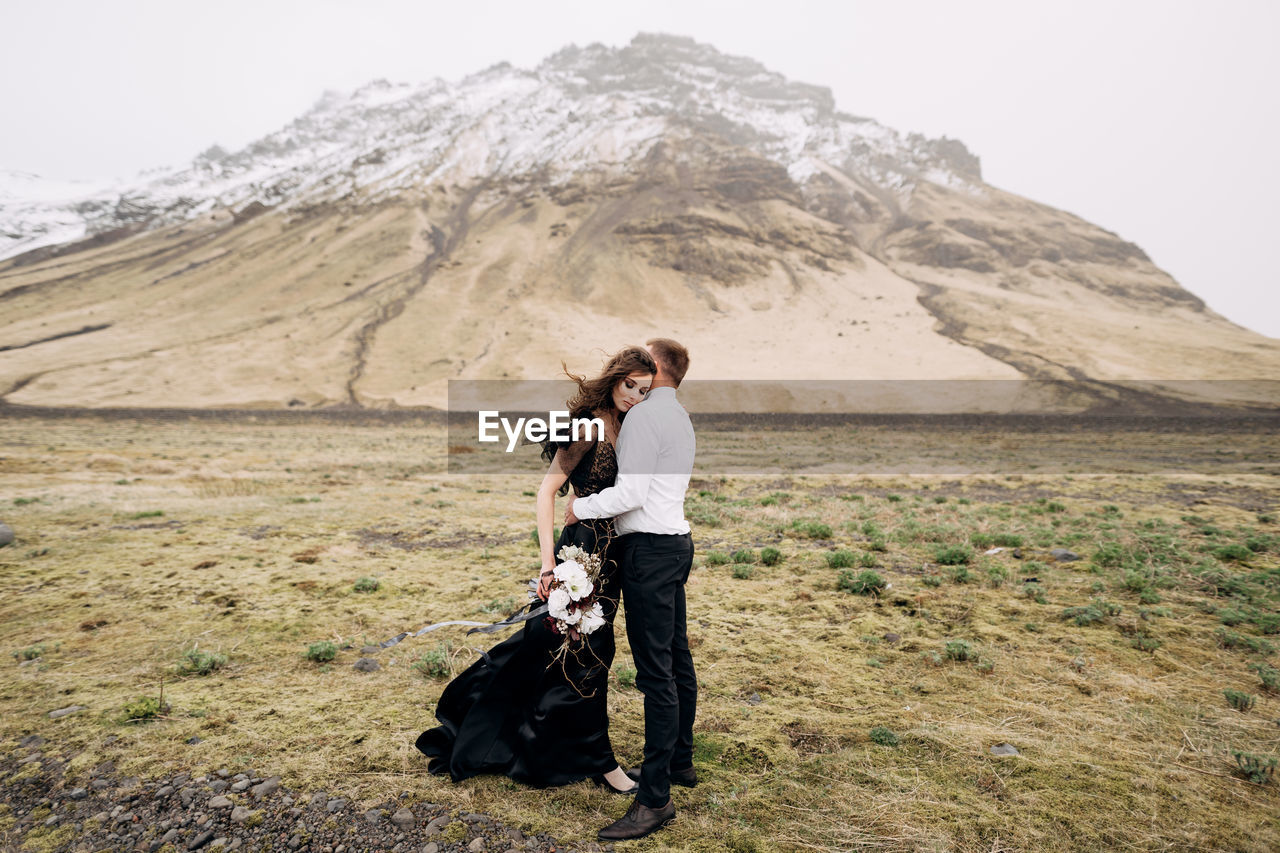 FULL LENGTH OF WOMAN WITH DOG ON MOUNTAINS