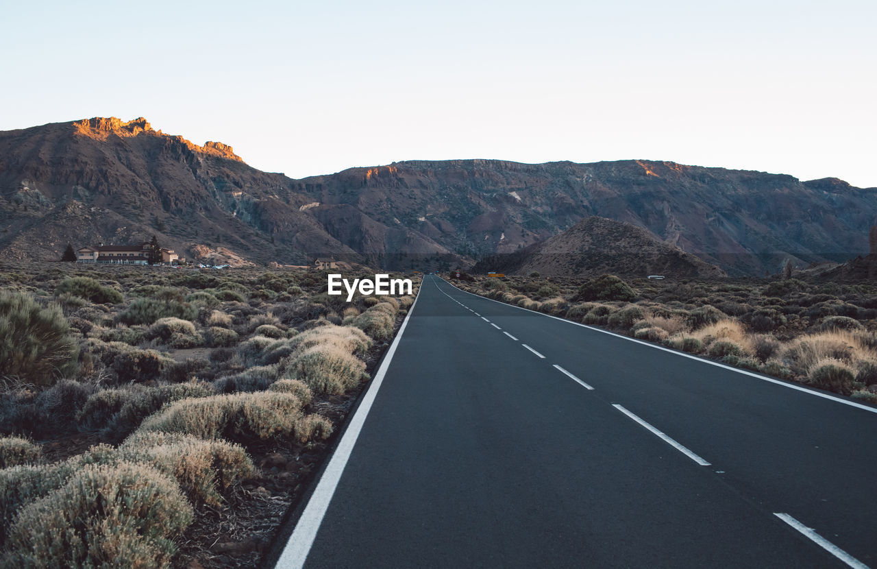 Road leading towards mountains against sky