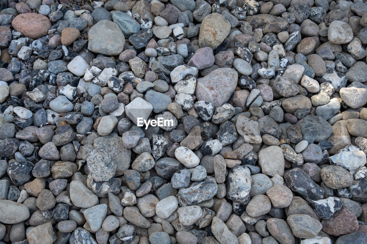 HIGH ANGLE VIEW OF STONES ON BEACH