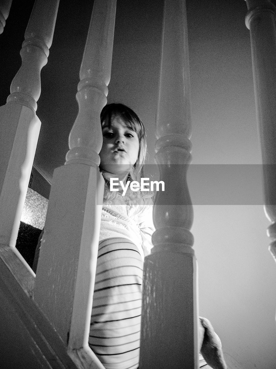 Low angle portrait of girl sitting on staircase at home