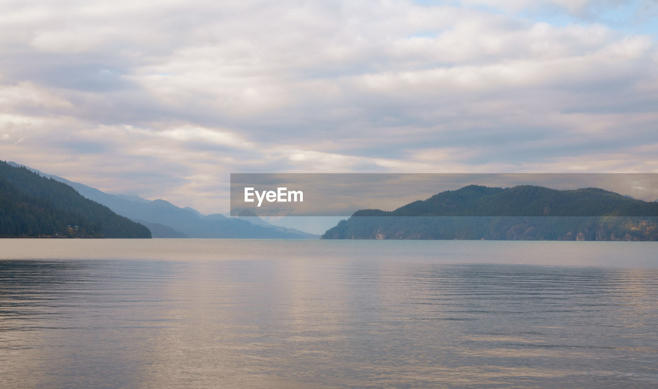 Scenic view of lake by mountains against sky