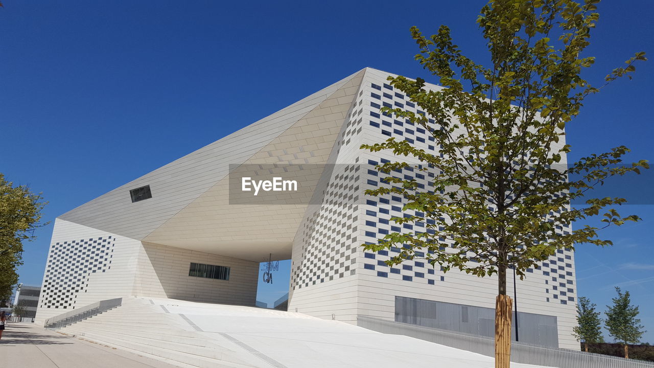 LOW ANGLE VIEW OF BUILDINGS AGAINST CLEAR BLUE SKY