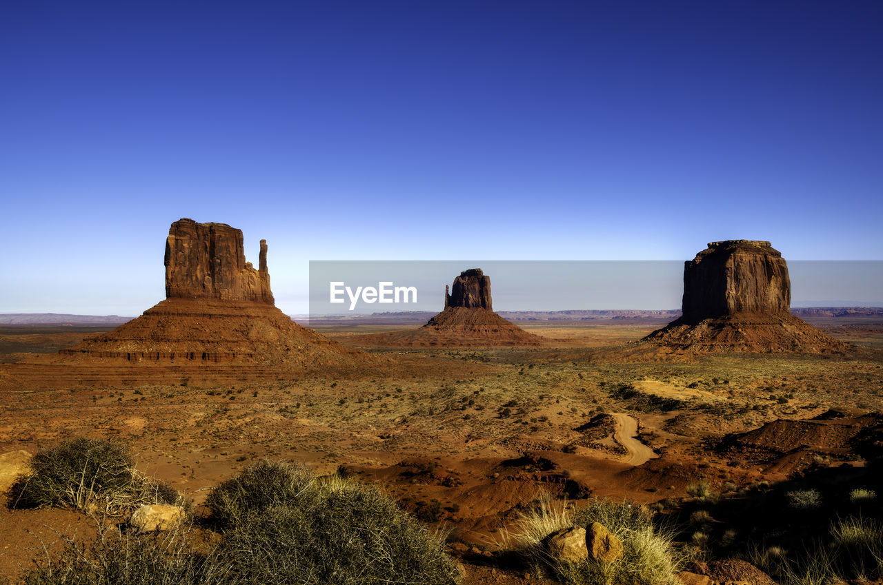 View of rock formations on landscape against blue sky