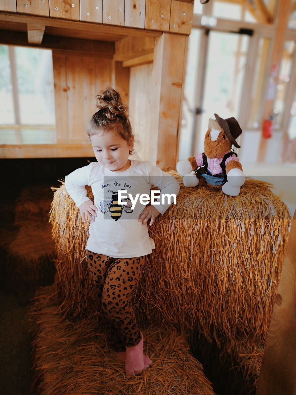 Girl dancing on hay bale at home