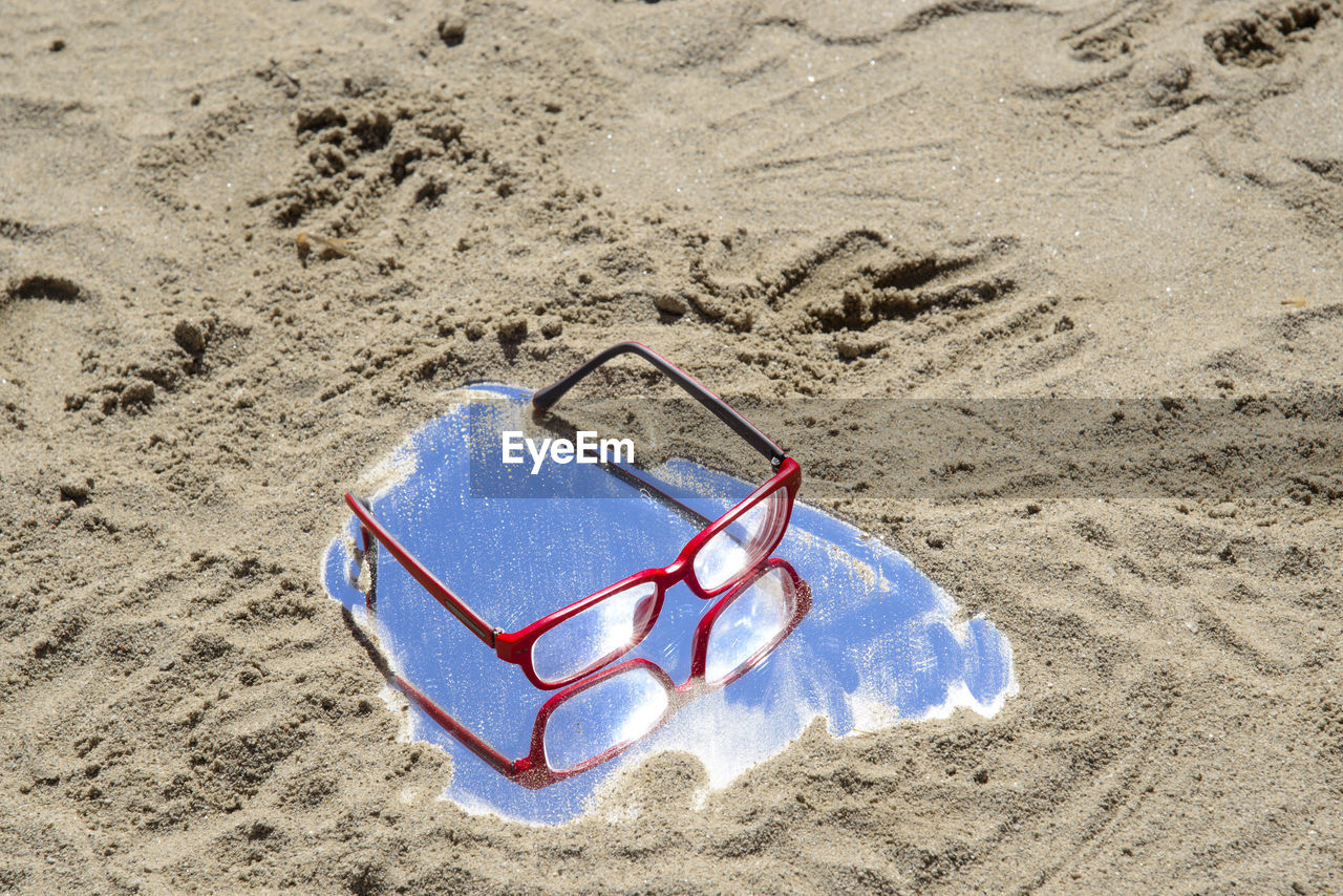 HIGH ANGLE VIEW OF SHOE ON SAND