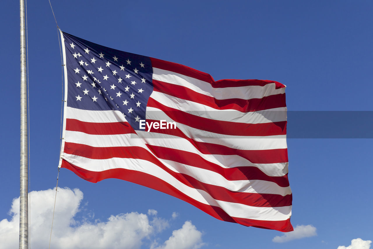 Low angle view of american flag against blue sky