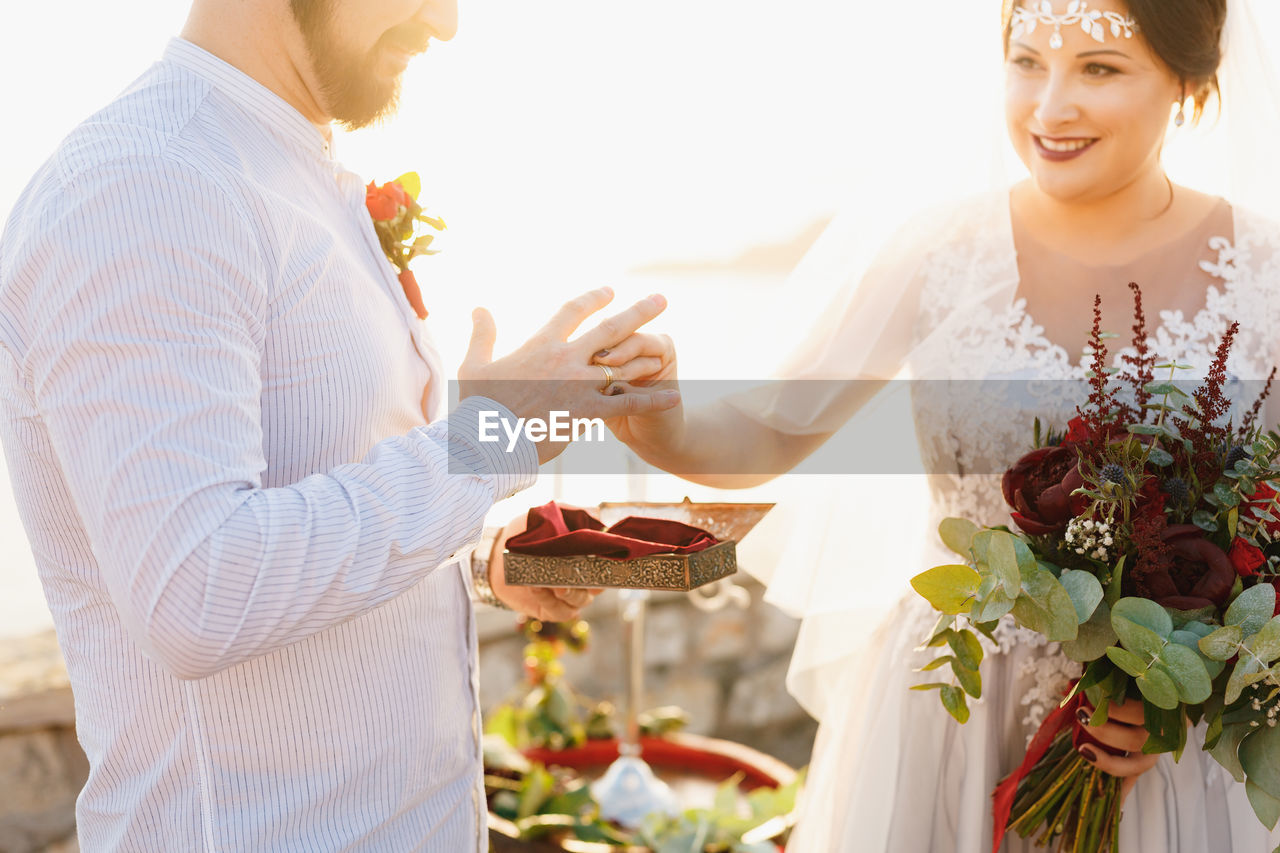 Low angle view of couple kissing on flower