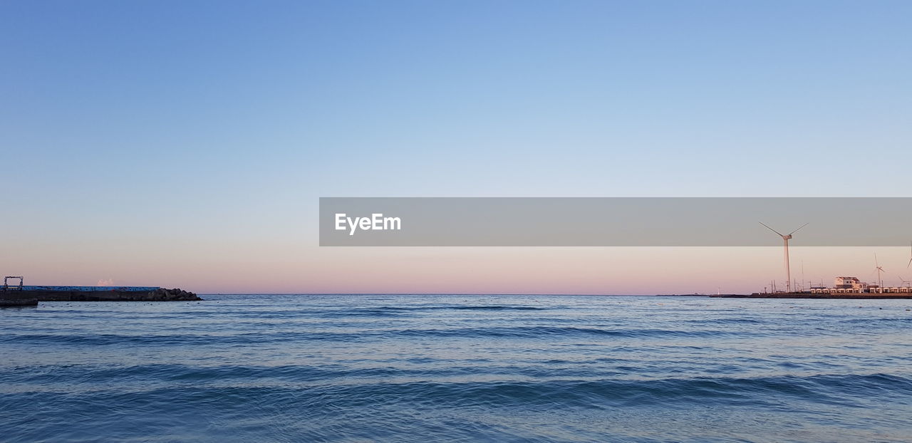 Scenic view of sea against clear sky during sunset