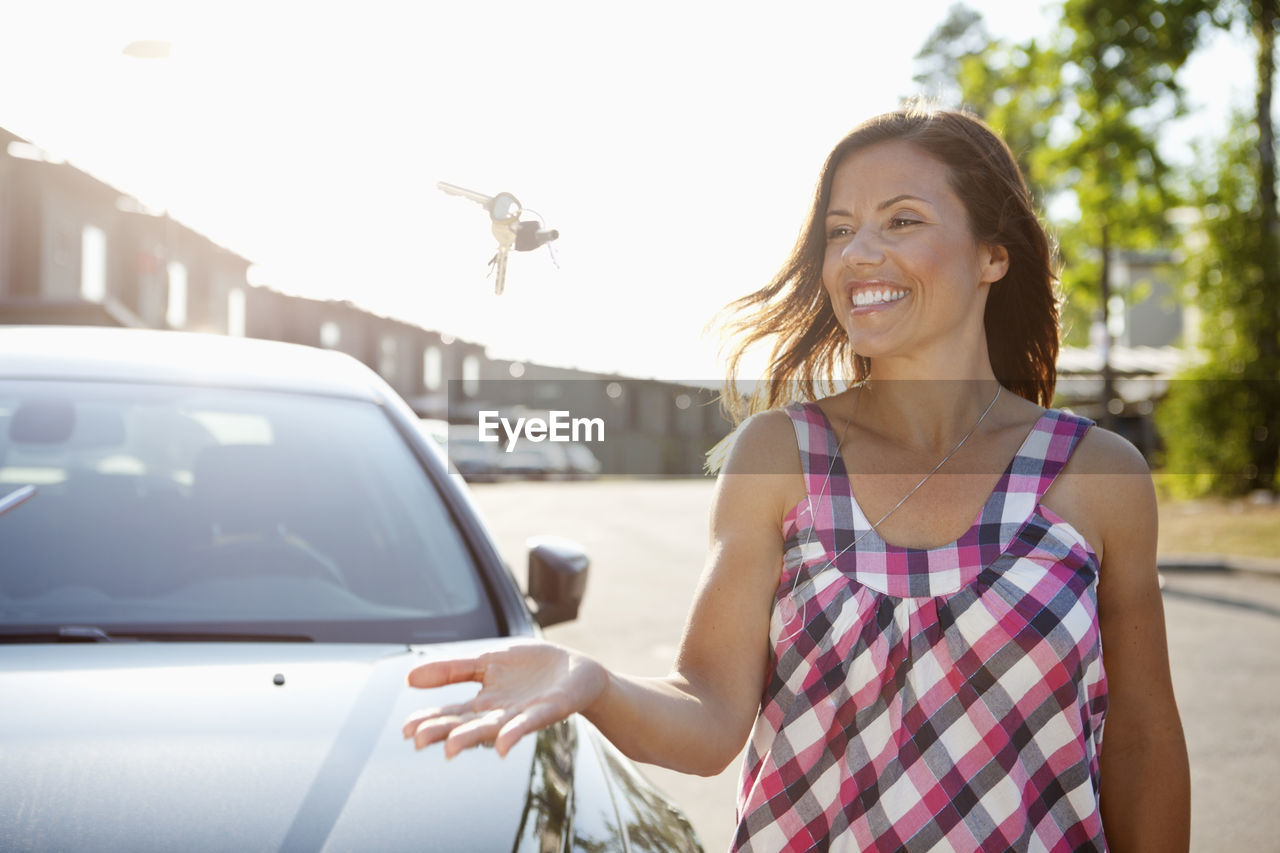 Happy woman throwing keys in the air