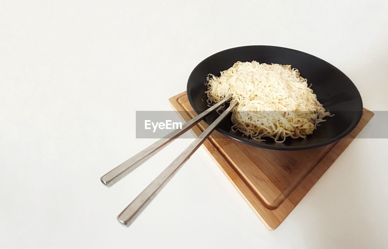 food and drink, food, chopsticks, wellbeing, studio shot, healthy eating, kitchen utensil, dish, asian food, indoors, rice - food staple, freshness, cuisine, bowl, no people, white background, high angle view, vegetable, meal, household equipment, eating utensil, rice, still life, pasta, wood, japanese food, spoon