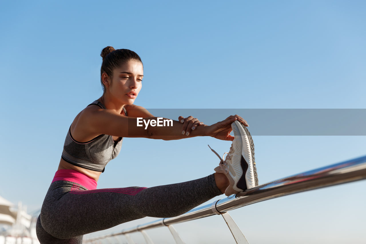 Low angle view of woman against clear sky