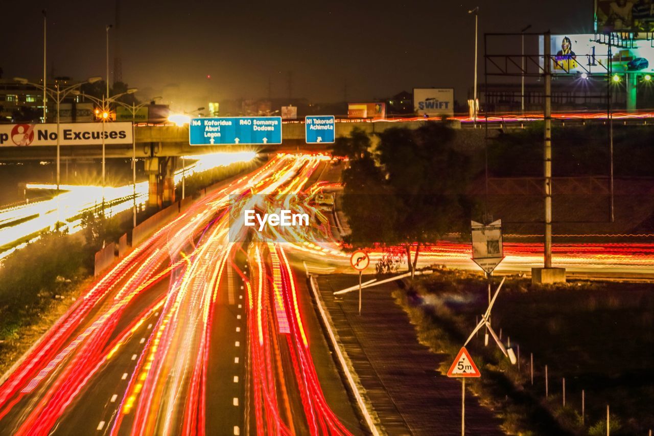 Illuminated light trail on highway at night