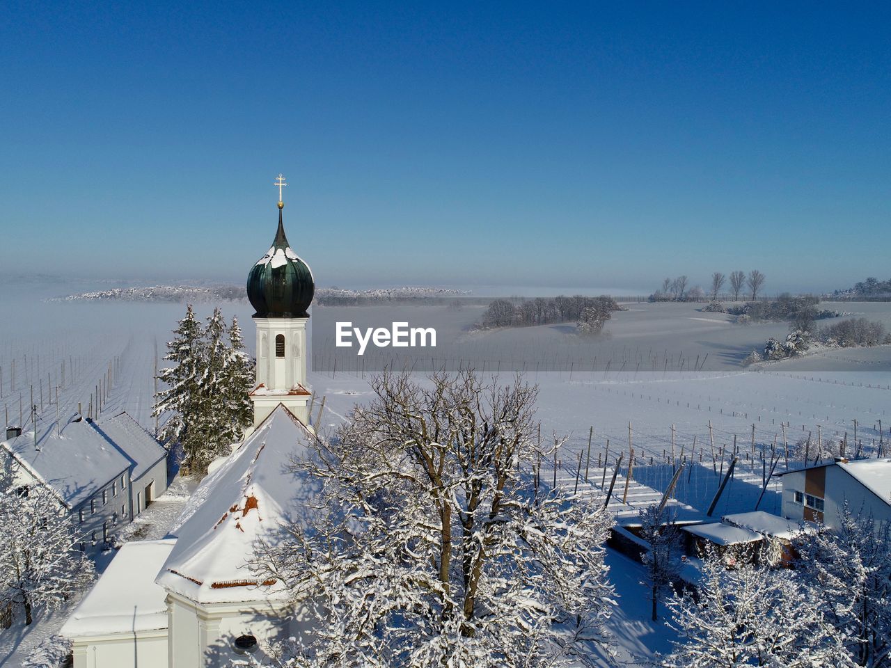 CHURCH BY BUILDING AGAINST BLUE SKY