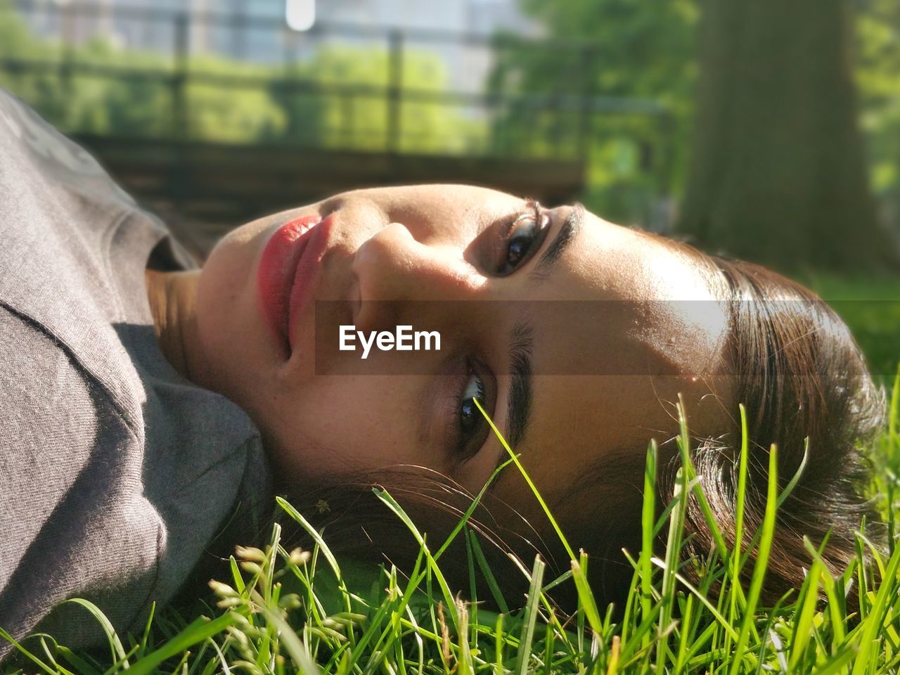 Portrait of mid adult woman lying on grassy field