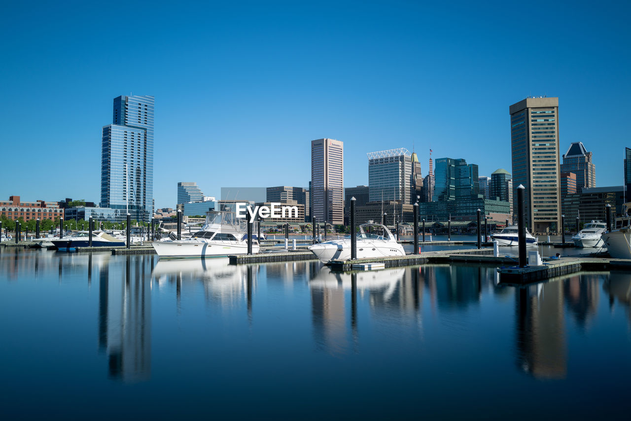 REFLECTION OF BUILDINGS IN CITY AGAINST BLUE SKY