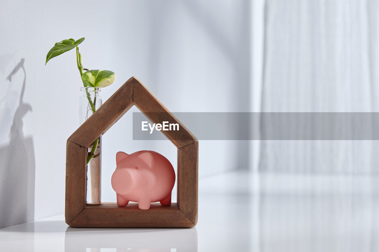 Hand made wooden house with with piggy bak near window