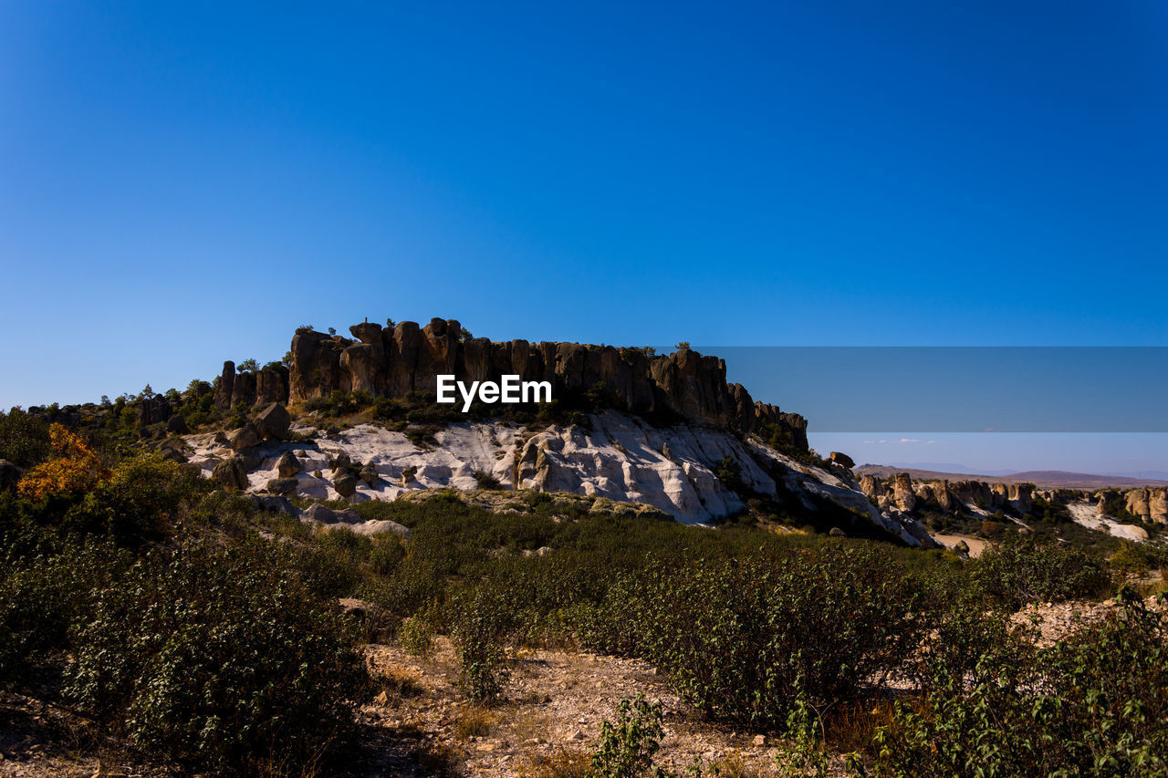 Scenic view of rocky mountains against clear blue sky