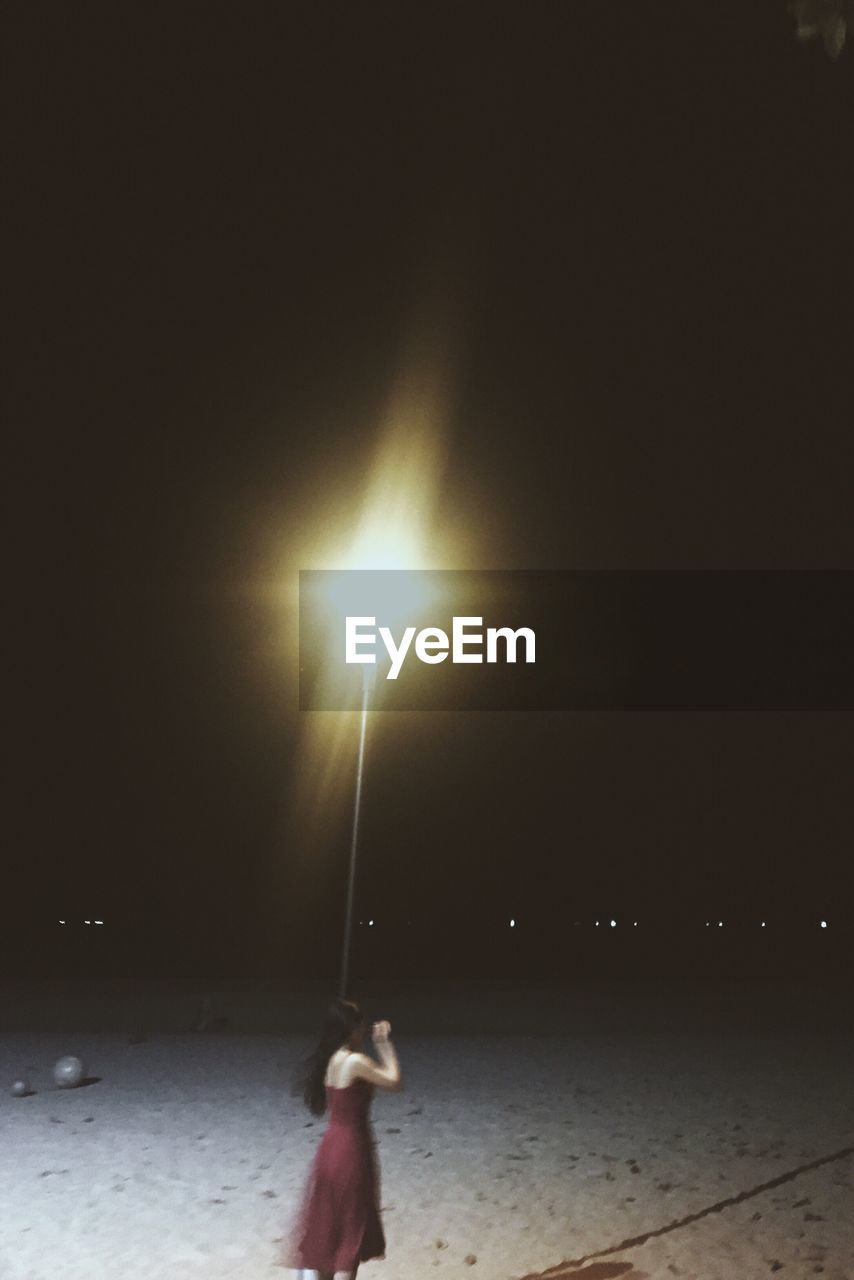 WOMAN STANDING AT BEACH