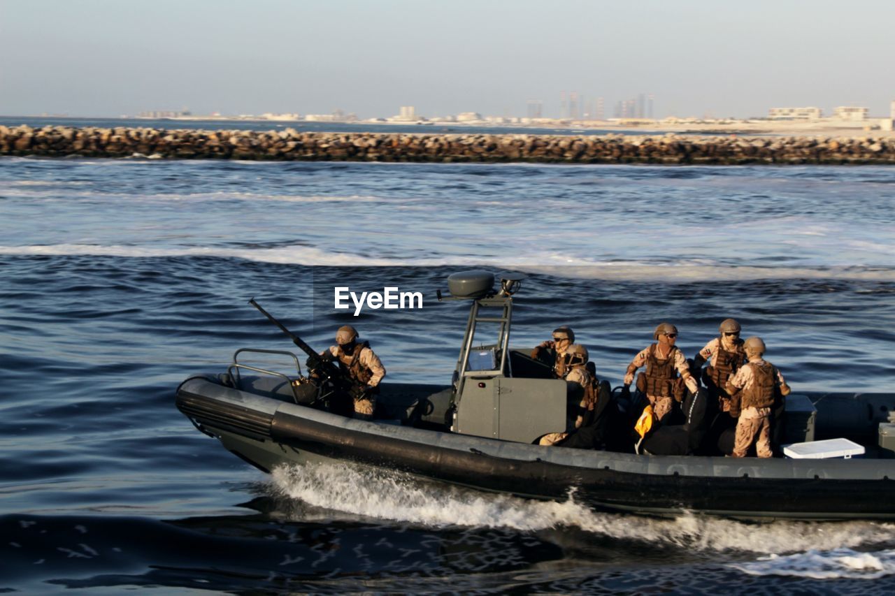 High angle view of army soldiers on boat in sea against sky