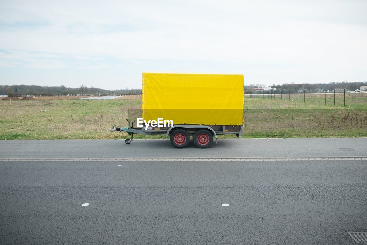 Vehicle trailer on road against sky