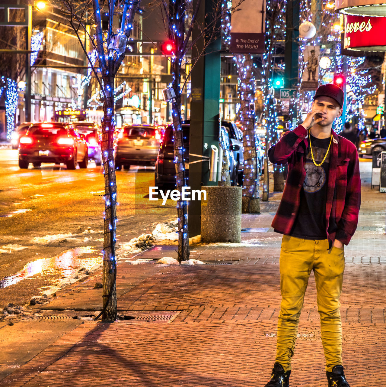 PORTRAIT OF SMILING YOUNG MAN STANDING IN CITY