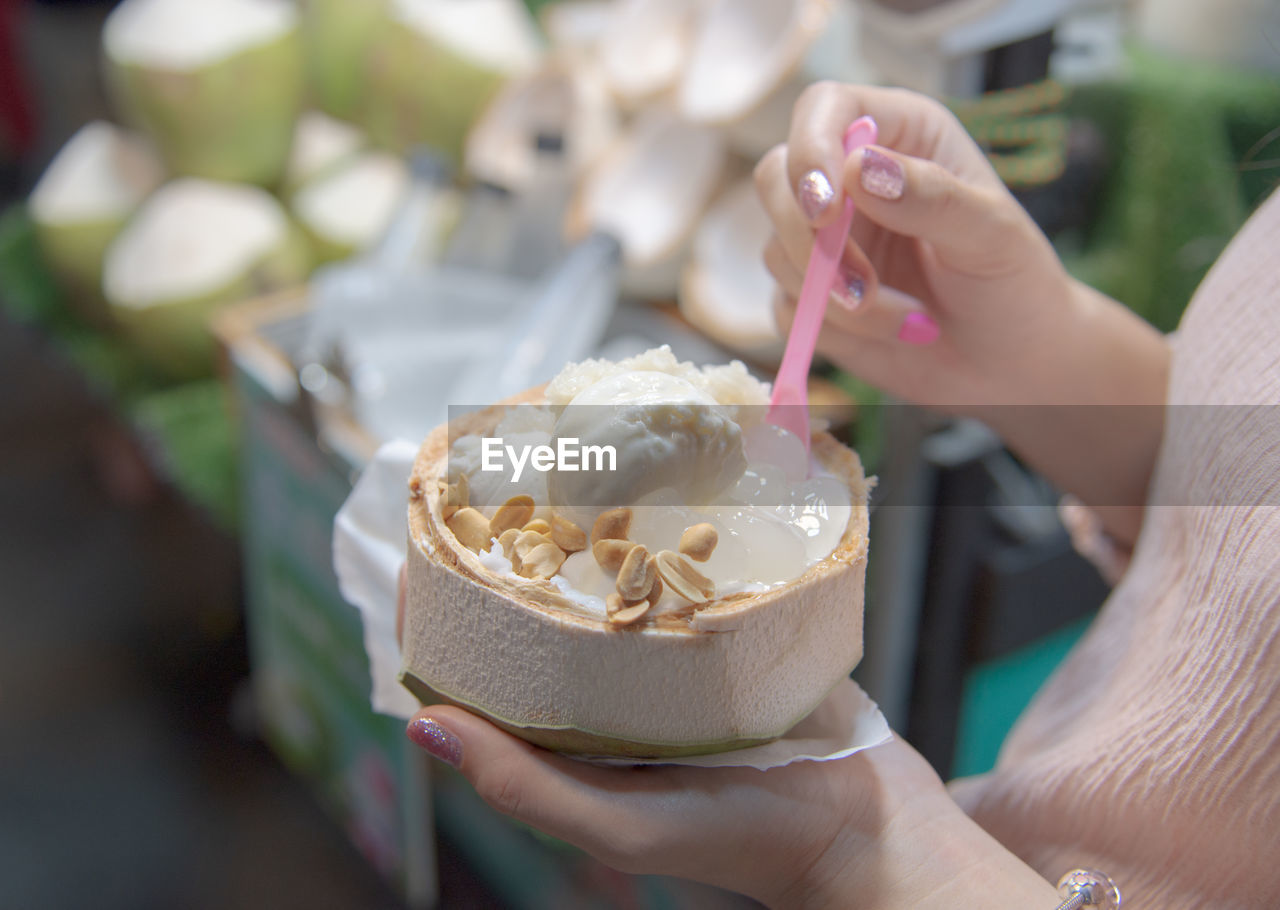 MIDSECTION OF PERSON HOLDING ICE CREAM CONE OUTDOORS