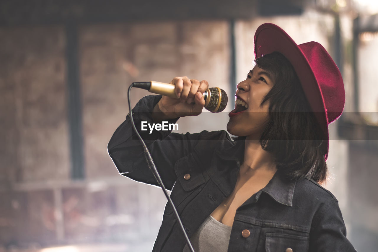 Young woman singing in microphone