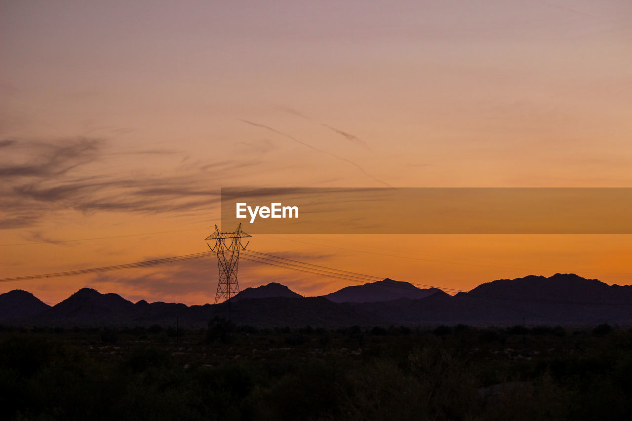 SILHOUETTE MOUNTAINS AGAINST ORANGE SKY