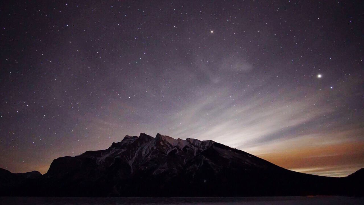 Scenic view of mountains against sky at night