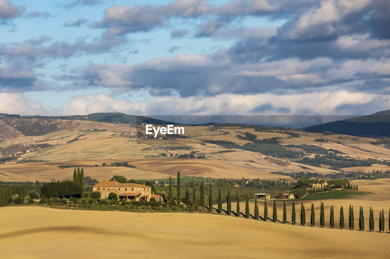 Italy, tuscany, castiglione d?orcia, cloudy sky over farmhouse in val d?orcia