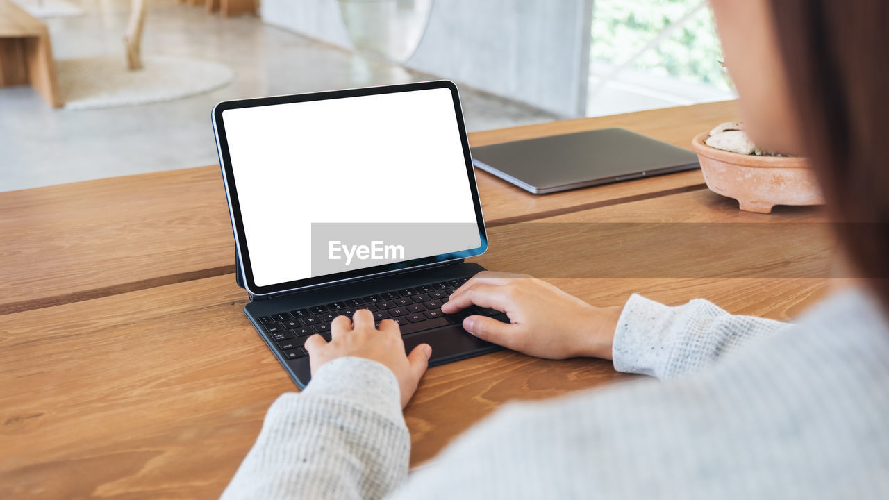 midsection of woman using digital tablet at table