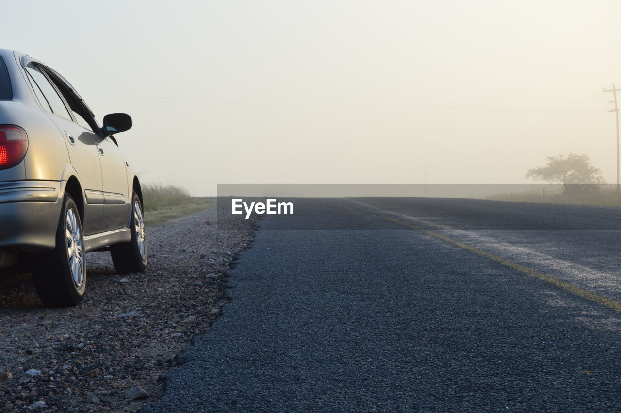 CARS ON ROAD AGAINST CLEAR SKY