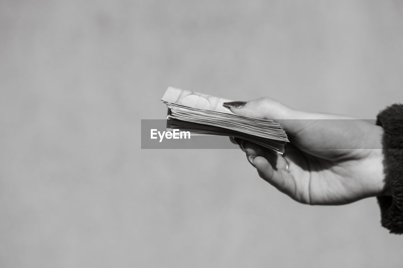 cropped hand of woman holding paper currency