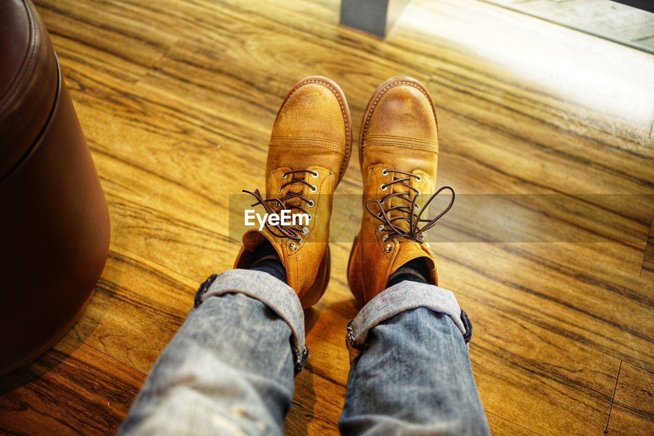 Low section of man sitting on wooden floor