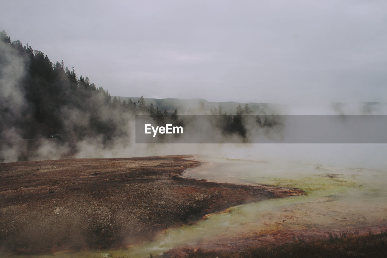 Smoke emitting from geyser against sky