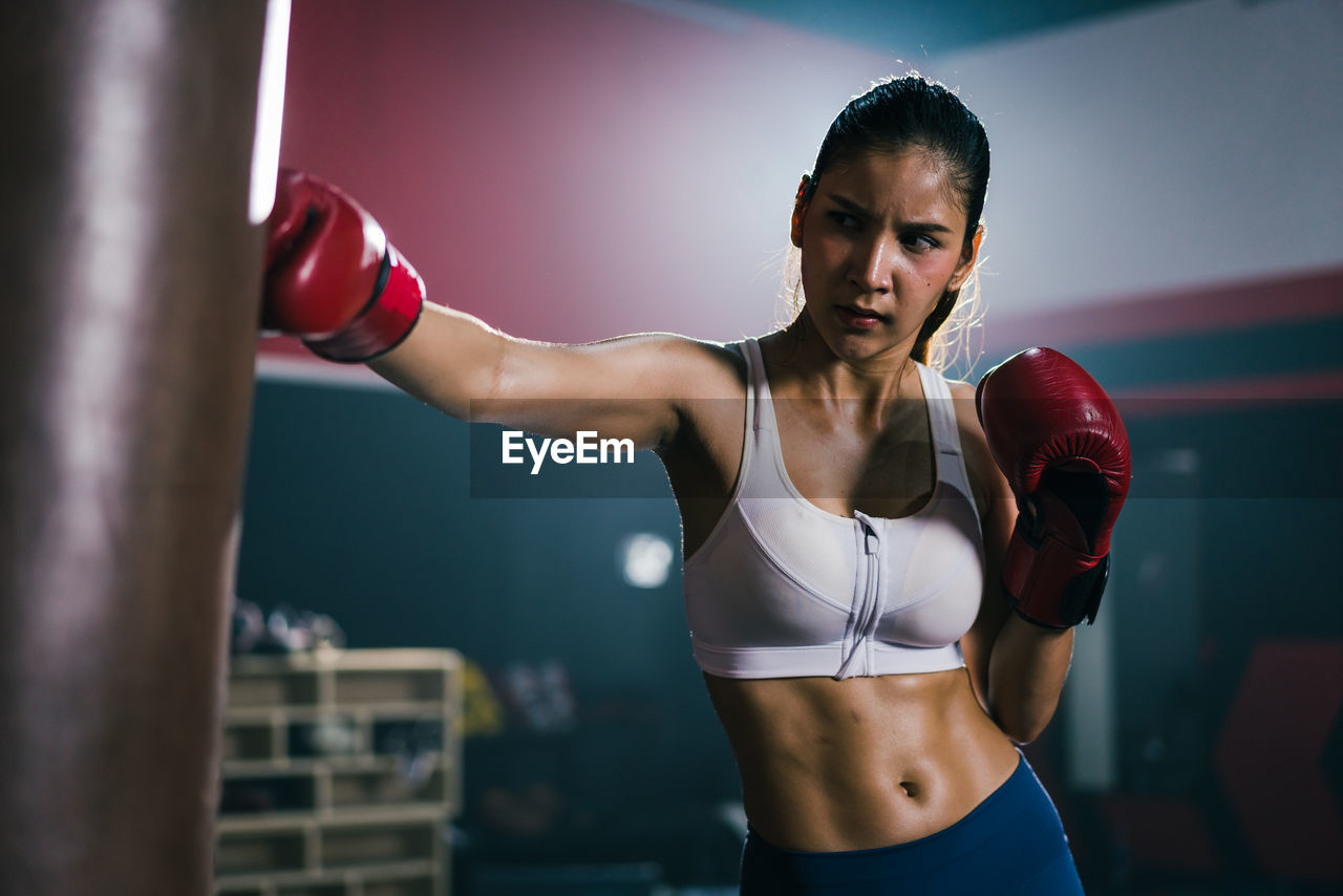 Concentrated young asian training boxing in the gym