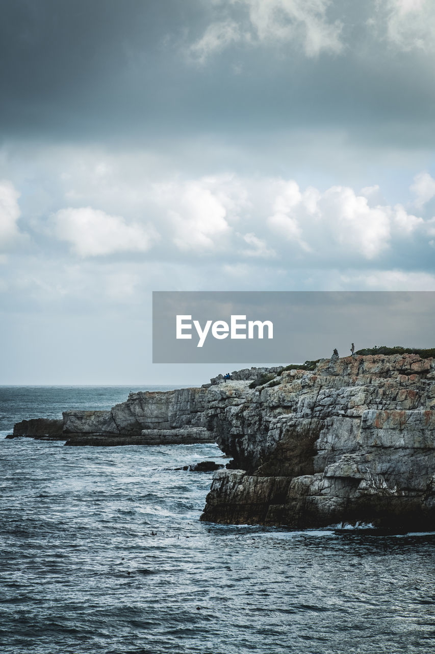 Rocks by sea against sky