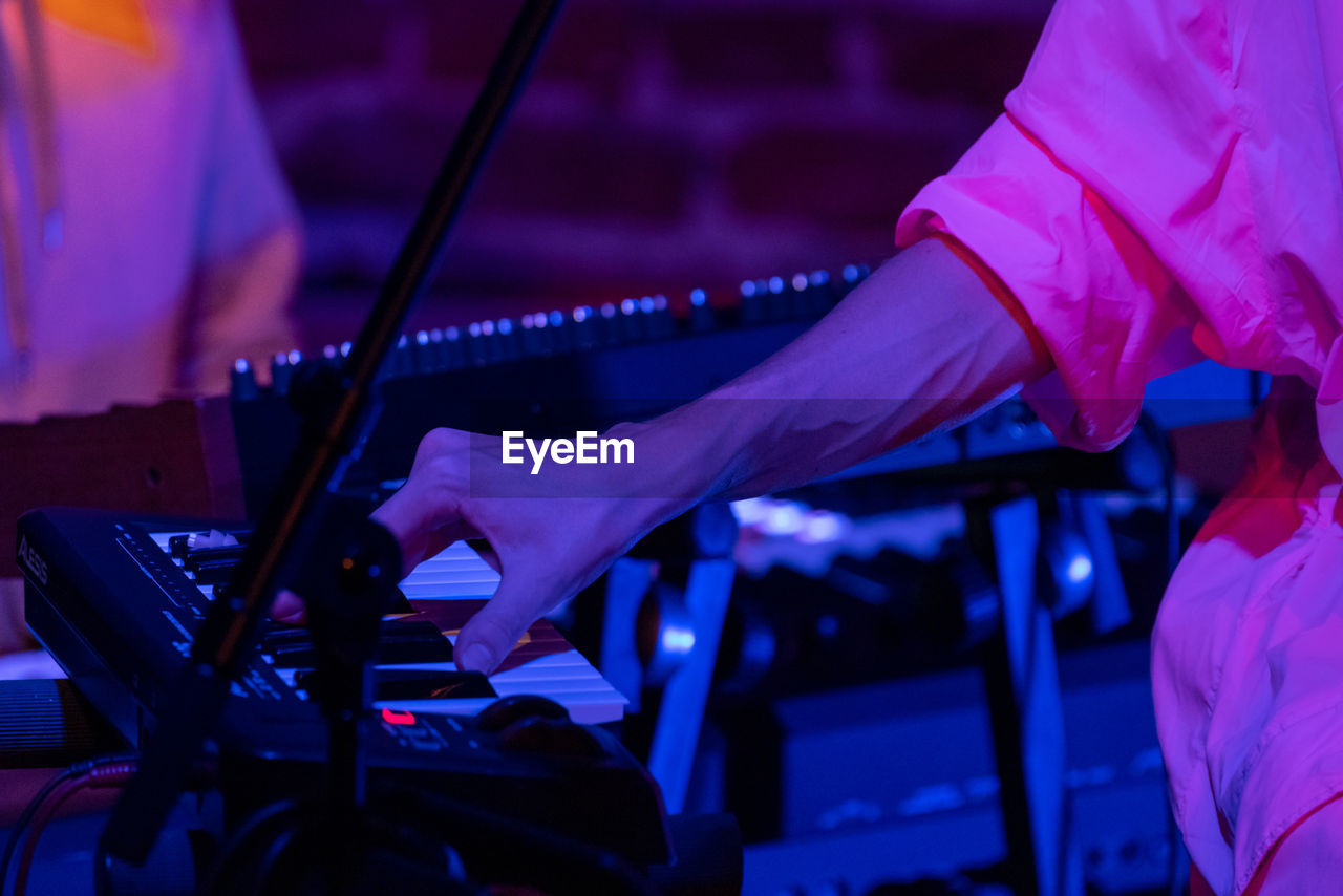 Midsection of man playing piano at music concert